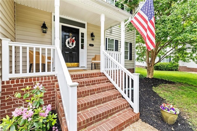 entrance to property featuring brick siding and covered porch