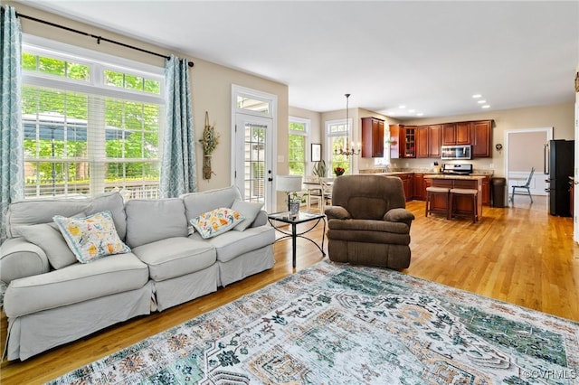 living room with plenty of natural light, light wood finished floors, and recessed lighting