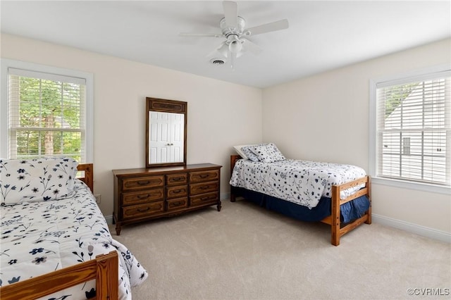 bedroom with light colored carpet, multiple windows, and baseboards