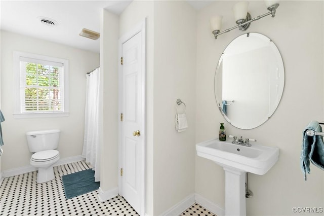full bath featuring toilet and baseboards