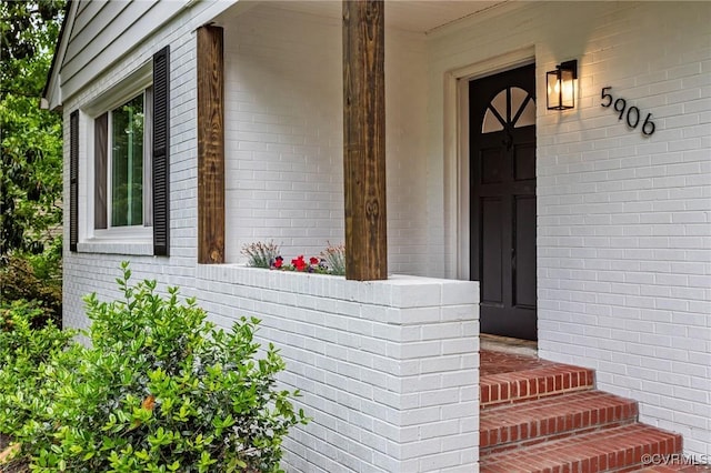 doorway to property featuring brick siding