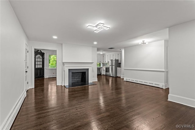 unfurnished living room featuring baseboard heating, a baseboard radiator, dark wood-style flooring, baseboards, and recessed lighting