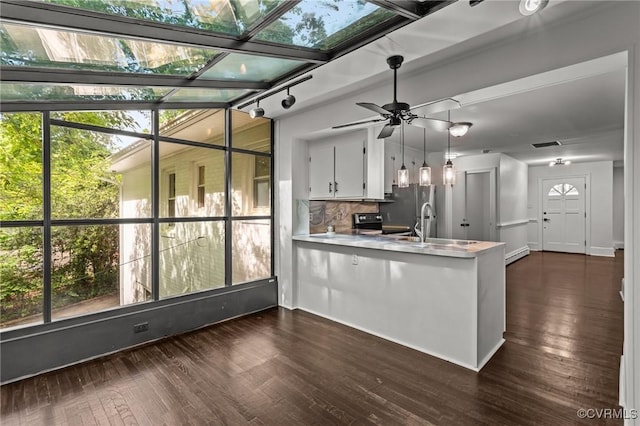 kitchen with a peninsula, light countertops, white cabinets, ceiling fan, and dark wood-style flooring