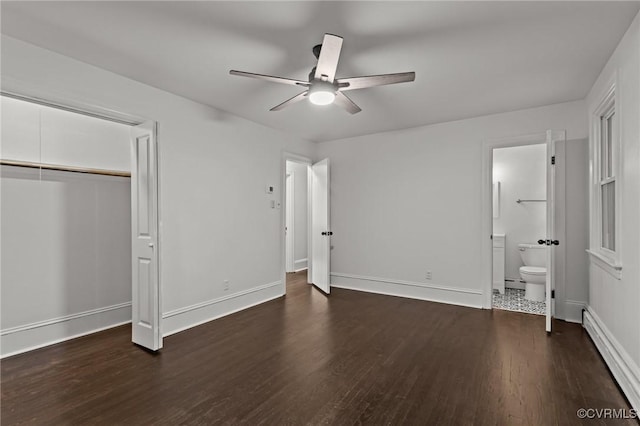 unfurnished bedroom featuring a baseboard radiator, wood finished floors, baseboards, and a closet