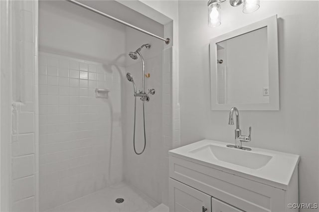 full bath featuring a tile shower and vanity
