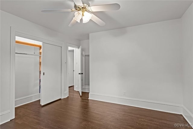 unfurnished bedroom featuring dark wood-type flooring, baseboards, a closet, and a ceiling fan