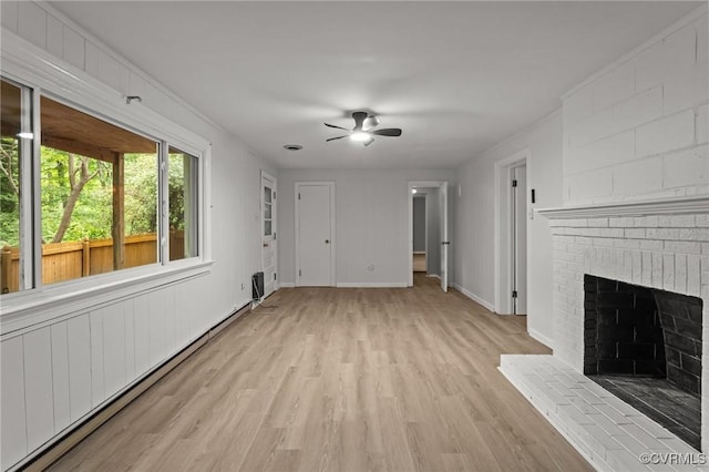 unfurnished living room with light wood-type flooring, a fireplace, ceiling fan, a baseboard radiator, and baseboards