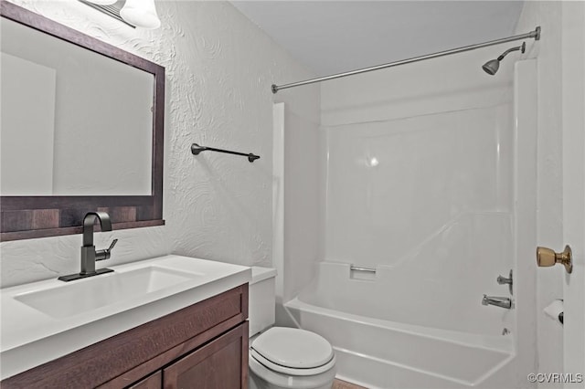 full bath featuring toilet, shower / tub combination, vanity, and a textured wall