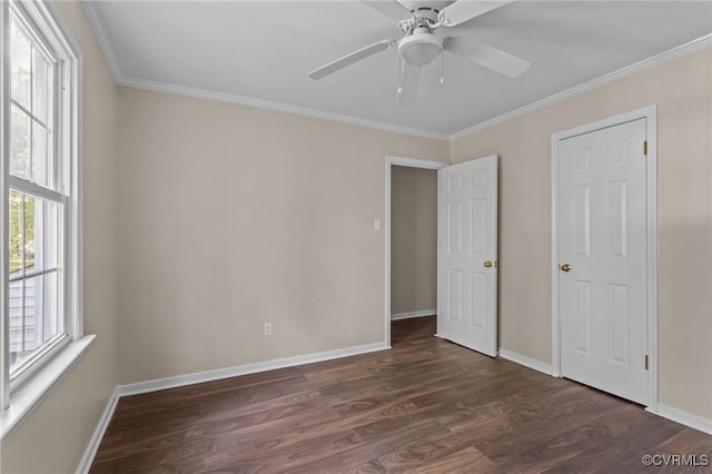 unfurnished bedroom featuring dark wood-type flooring, ornamental molding, baseboards, and ceiling fan
