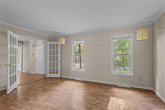unfurnished room with french doors, ornamental molding, healthy amount of natural light, and baseboards