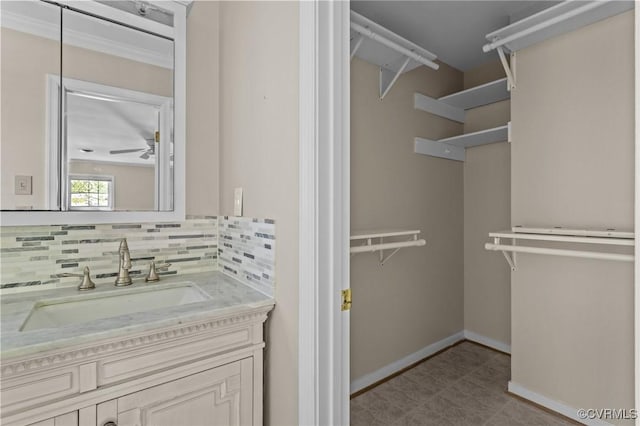 bathroom featuring backsplash, baseboards, and vanity