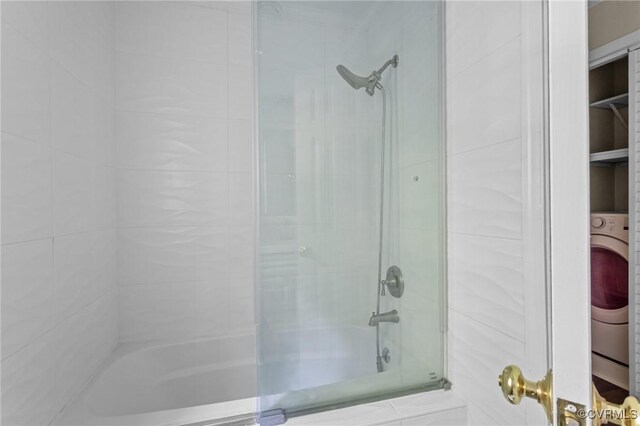 bathroom with shower / bathtub combination and washer / dryer