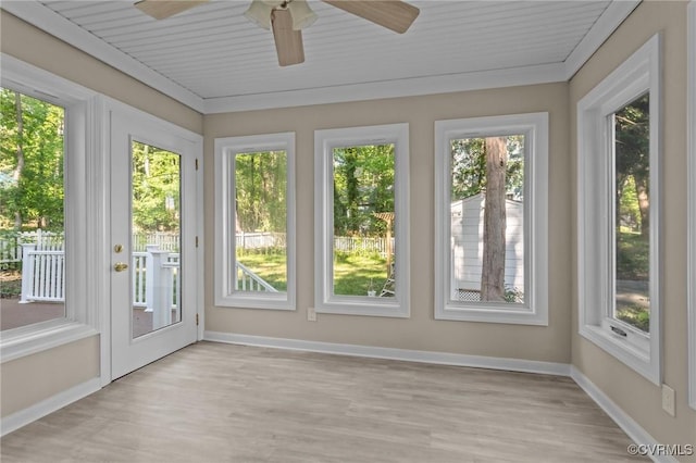 unfurnished sunroom with plenty of natural light, wood finished floors, and baseboards