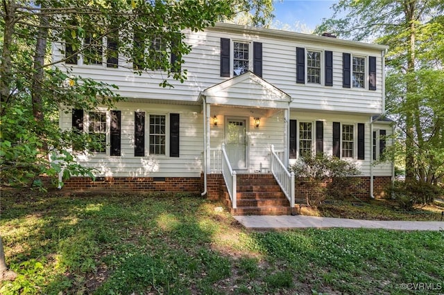 colonial-style house featuring a front lawn and crawl space