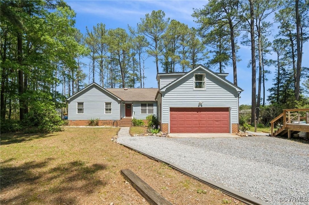 view of front of house with a front lawn, driveway, brick siding, and a garage