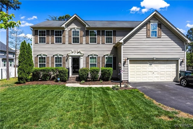 colonial house featuring asphalt driveway, a front yard, and an attached garage