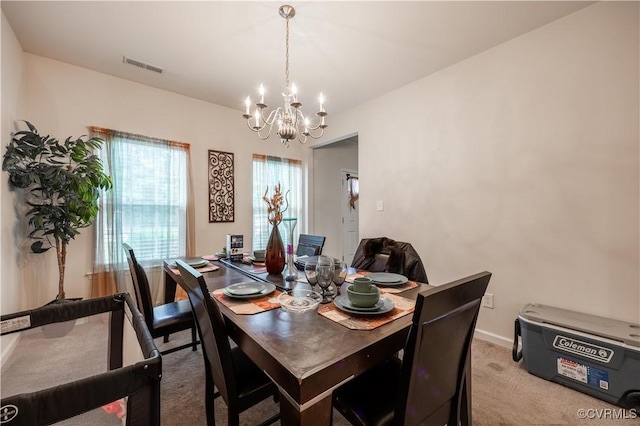 dining area featuring a chandelier, light colored carpet, and baseboards