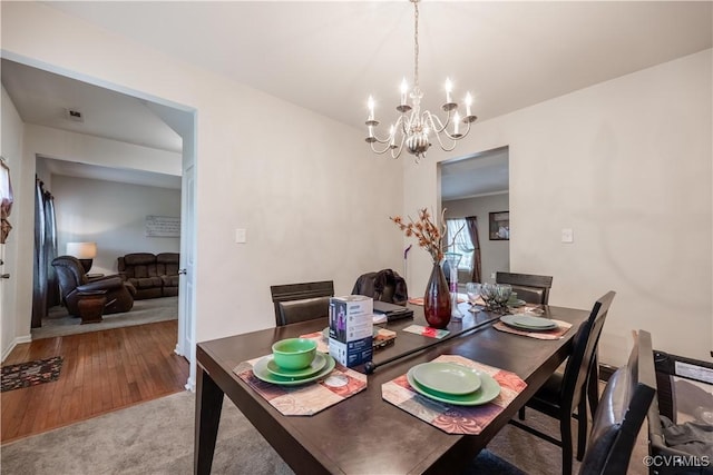 dining room featuring a chandelier, wood finished floors, and baseboards