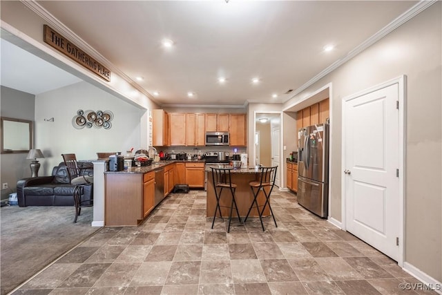 kitchen with appliances with stainless steel finishes, a kitchen bar, open floor plan, recessed lighting, and dark stone counters