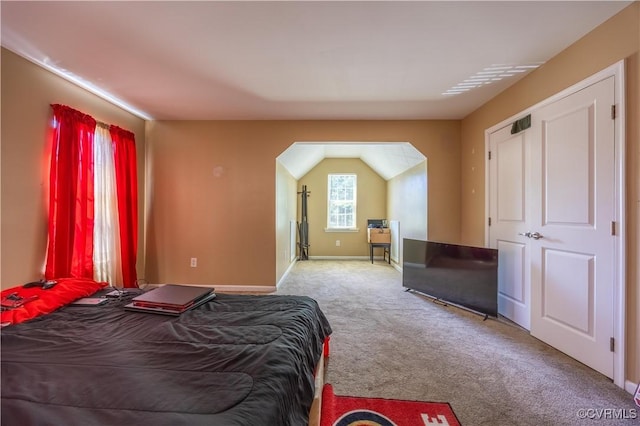 carpeted bedroom featuring baseboards and arched walkways
