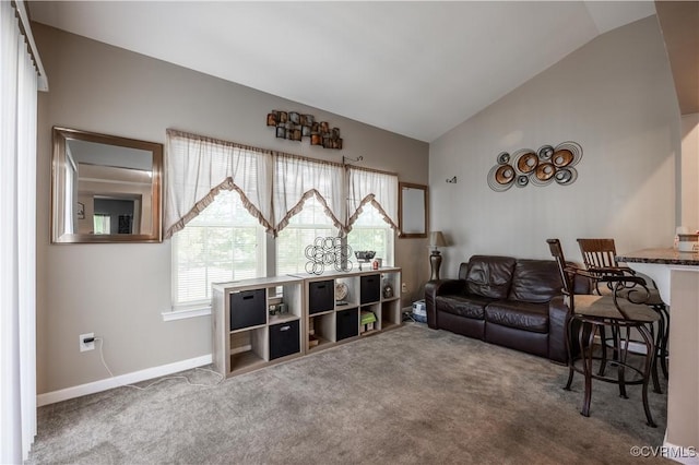 carpeted living area featuring vaulted ceiling and baseboards