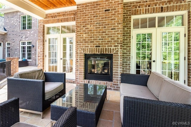 exterior space with an outdoor living space with a fireplace and french doors