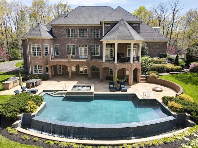 back of house featuring fence, a patio area, a fenced in pool, and brick siding