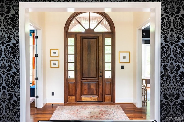 foyer entrance with dark wood-style flooring and baseboards