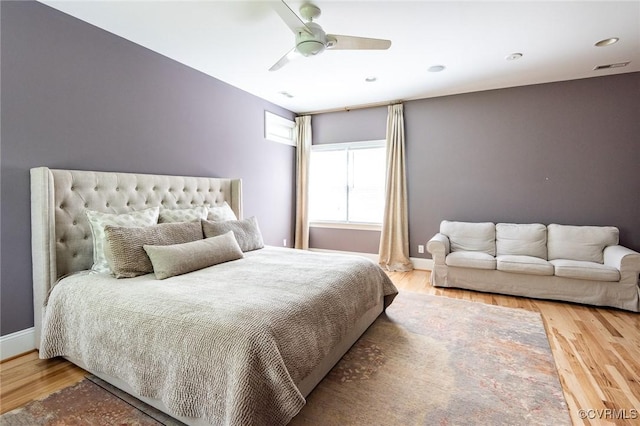 bedroom featuring ceiling fan, baseboards, visible vents, and wood finished floors