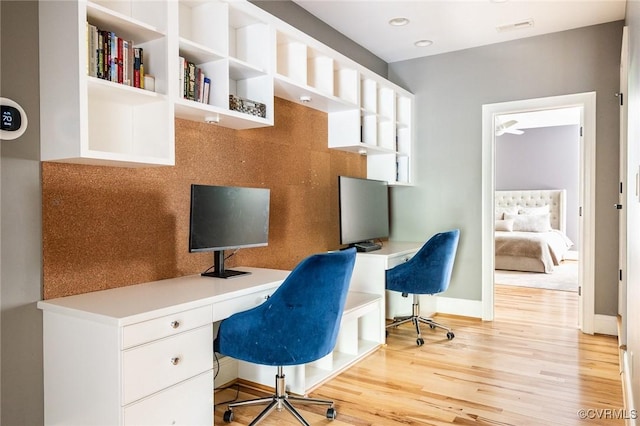 office area with recessed lighting, baseboards, visible vents, light wood-style floors, and built in desk
