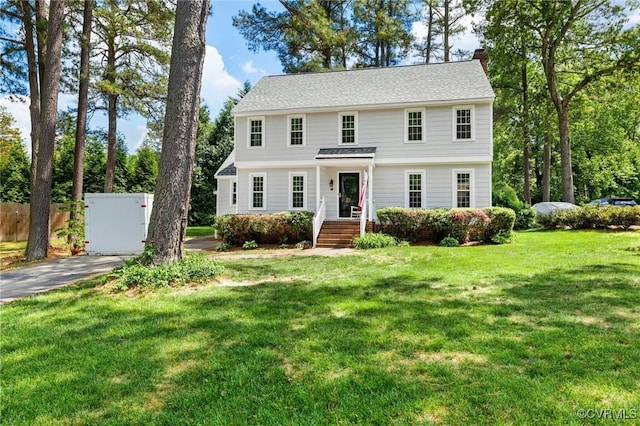 view of front of property with a front lawn, a chimney, and fence