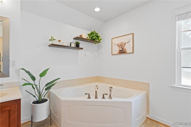 full bathroom featuring a bath, vanity, and baseboards