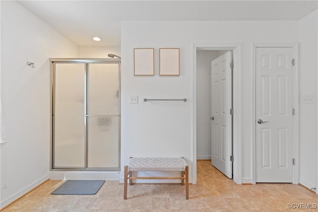 bathroom with a stall shower, baseboards, and recessed lighting