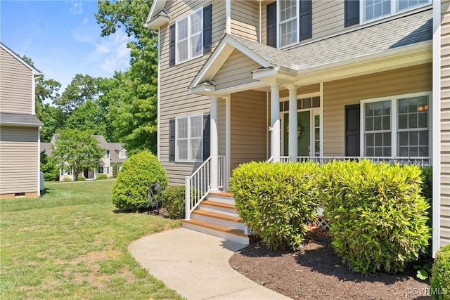 property entrance with covered porch, a lawn, and a shingled roof