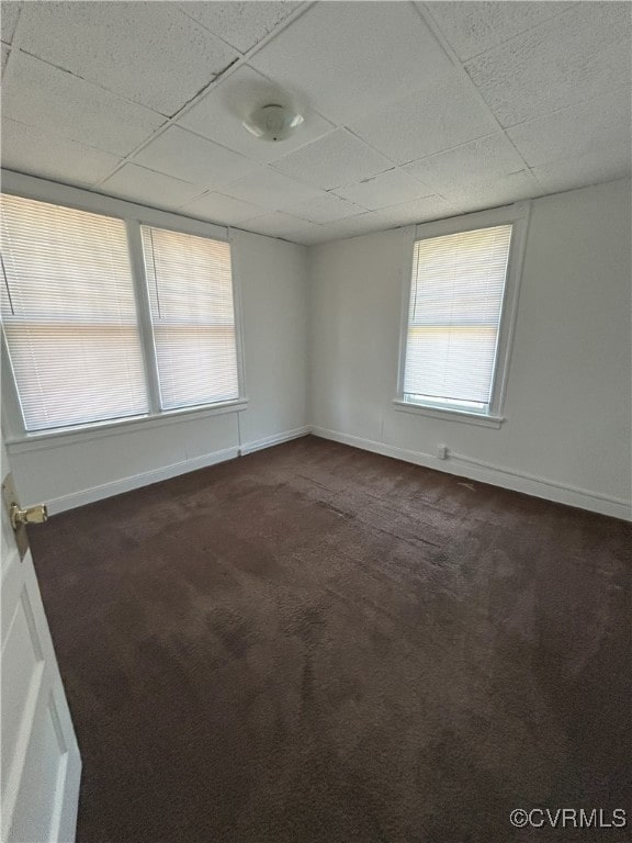 2307 Wright Ave, Richmond, VA 23224 - empty room with dark colored carpet, a drop ceiling, and healthy amount of natural light