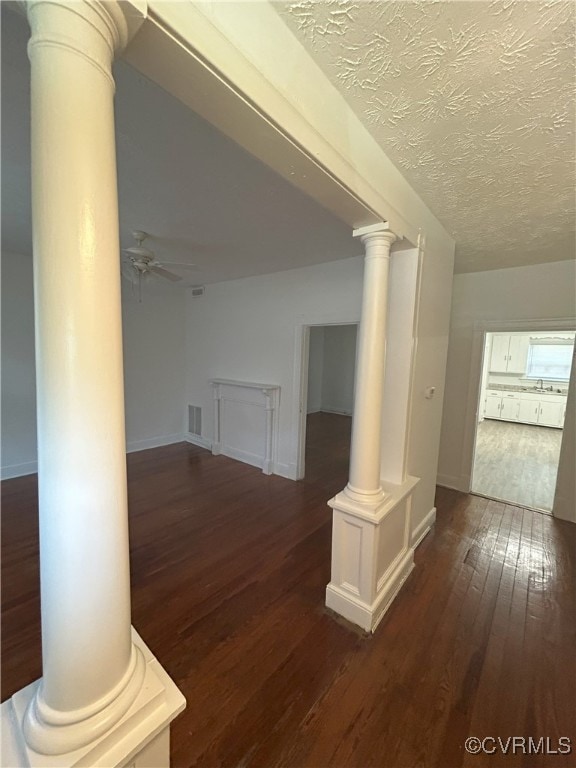2307 Wright Ave, Richmond, VA 23224 - corridor featuring ornate columns, dark wood-style flooring, and a textured ceiling