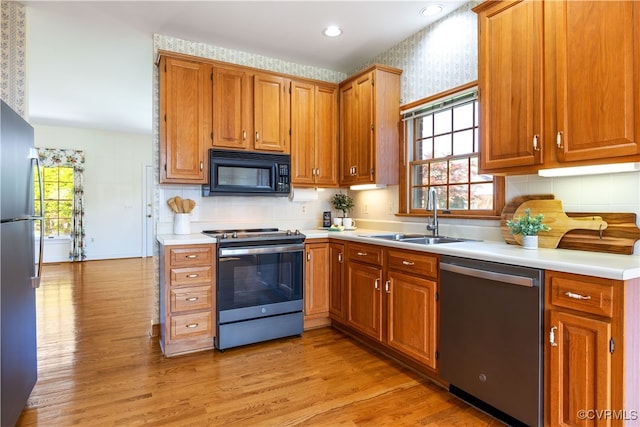 4916 Breckstone Pl, North Chesterfield, VA 23234 - kitchen featuring appliances with stainless steel finishes, a sink, light wood-style floors, plenty of natural light, and wallpapered walls