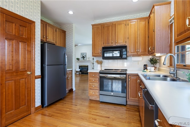 4916 Breckstone Pl, North Chesterfield, VA 23234 - kitchen featuring black appliances, a sink, light wood-style flooring, light countertops, and brown cabinets
