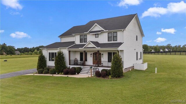 3307 Colston Ct, Powhatan, VA 23139 - view of front of home with board and batten siding, fence, a shingled roof, a porch, and a front lawn