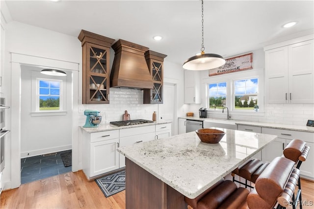 3307 Colston Ct, Powhatan, VA 23139 - kitchen with a breakfast bar area, glass insert cabinets, a sink, appliances with stainless steel finishes, and custom range hood