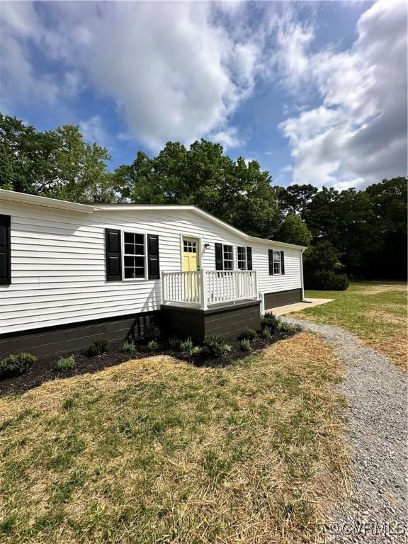 manufactured / mobile home with a deck, driveway, and a front yard