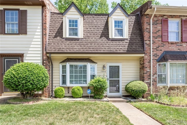 view of front of property with a shingled roof and a front yard