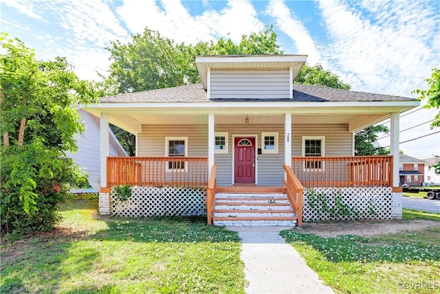 bungalow with covered porch, a front yard, and roof with shingles
