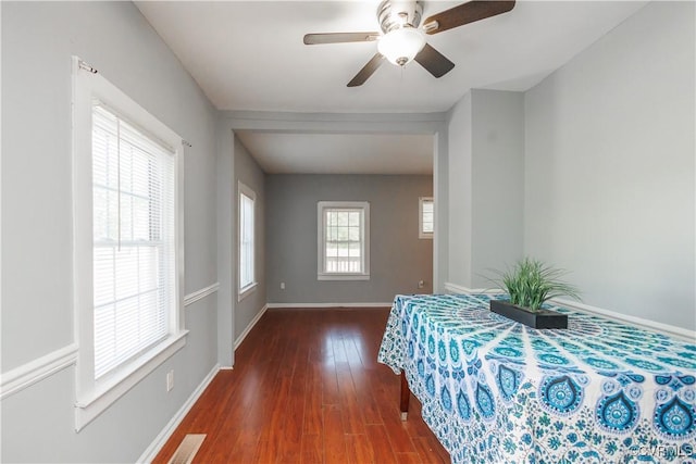 bedroom with wood finished floors, baseboards, and a ceiling fan