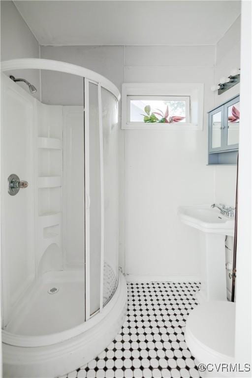 bathroom featuring a stall shower, tile patterned floors, and toilet