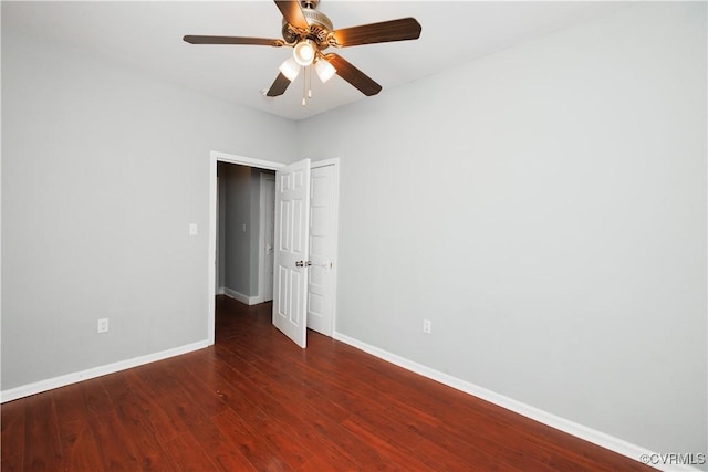 spare room featuring baseboards, wood finished floors, and a ceiling fan