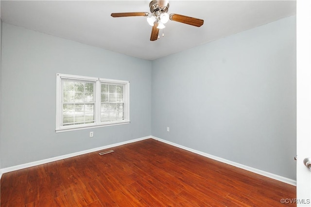 spare room with wood finished floors, baseboards, and a ceiling fan
