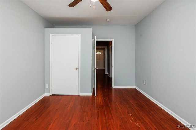 unfurnished bedroom featuring wood finished floors, baseboards, and a ceiling fan
