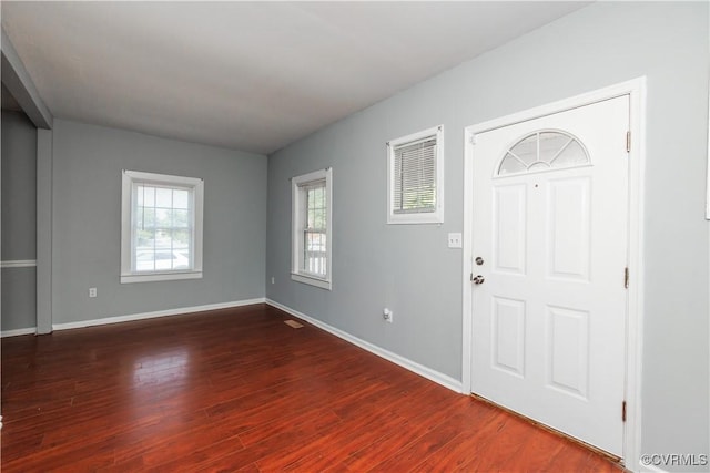 foyer entrance featuring baseboards and dark wood-style flooring