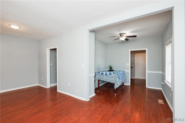 unfurnished room featuring a ceiling fan, wood finished floors, and baseboards